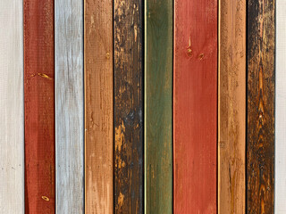 Colorful texture of painted in different bright colors wooden boards close up. Colorful surface of wooden wall from painted boards close-up.