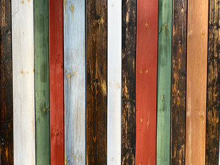 Colorful texture of painted in different bright colors wooden boards close up. Colorful surface of wooden wall from painted boards close-up.