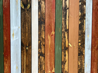 Colorful texture of painted in different bright colors wooden boards close up. Colorful surface of wooden wall from painted boards close-up.