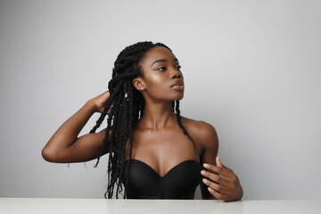 Gorgeous young African American woman with long braids posing over white.