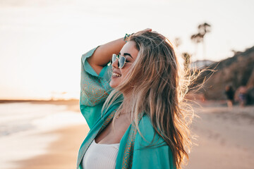 Portrait of one young woman at the beach looking at the sea enjoying free time and freedom outdoors. Having fun relaxing and living happy moments..