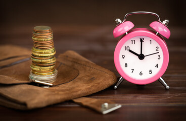 Coins stack with alarm clock, retirement savings and pension financial planning