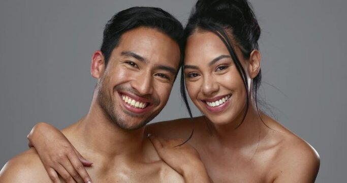 Couple, smile and care for skincare, face and portrait with moisturizer in studio by gray background. Happy people, dermatology and hug for cosmetics, hydration and natural treatment for interracial