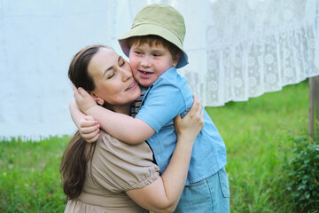 Obraz premium summer day, amidst hanging laundry, a mom and her little boy share joyful play and embraces. This authentic moment highlights the importance of nurturing bonds for a child s well-being.