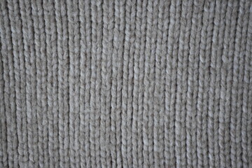 The texture of fabric thick beige sweater close-up. Knitted texture background