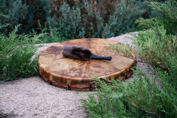 A shaman's tambourine made of genuine leather lies on a stone.