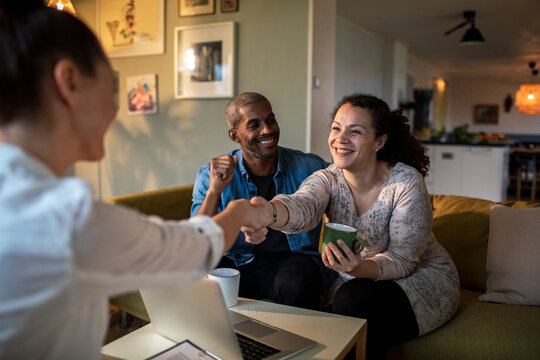 Middle aged mixed couple consulting their financial advisor in the living room at home