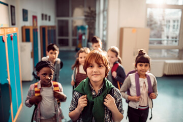 Portrait of young and diverse group of children going to class at their middle school hallway