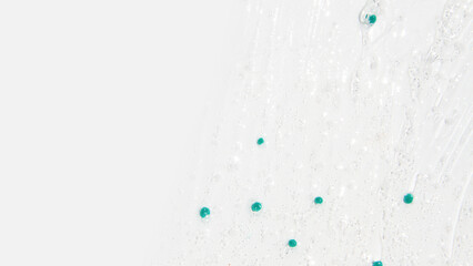 Transparent gel with blue granules smeared serum on a white background