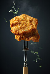 Hot fried schnitzel on a fork.