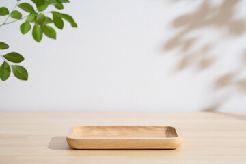 Minimal wood podium table top blurred green leaf plant on white space nature background.Beauty cosmetic natural product display.