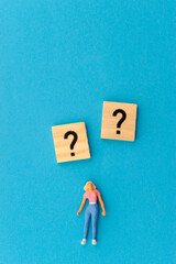 woman miniature figurine and question marks symbols 
