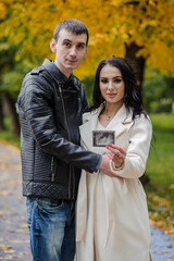 A man hugs his pregnant wife. Woman holding ultrasound photo of baby