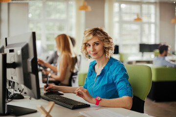 Portrait of a young woman working on the computer in a modern office