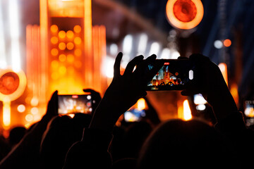 Crowd at a music festival. They are recording the show with their smartphones camera.