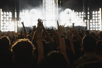 The crowd on the dance floor during the music show, happy people with raised hands