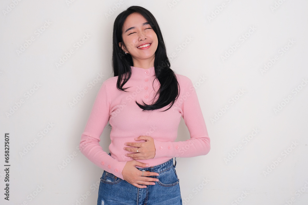 Wall mural asian young woman touching his stomach with relieved expression