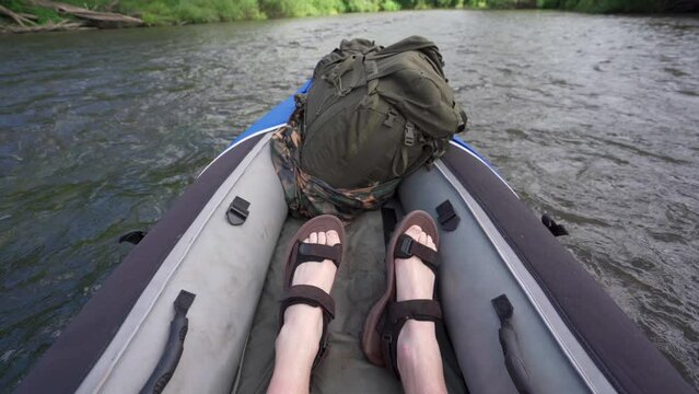 The feet of a person kayaking down a river