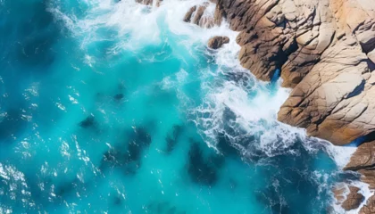Fototapeten Aerial View of Turquoise Ocean Waves Crashing on Rocky Shore © K