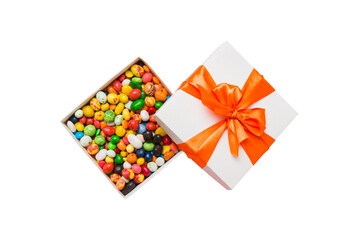 Set of different sweet candy in a paper box with a satin ribbon on a colored background. Holiday concept