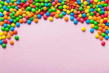 Mixed collection of colorful candy, on colored background. Flat lay, top view. frame of colorful chocolate coated candy