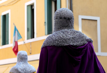 medieval knight with purple clothes and protection on head called chain mail