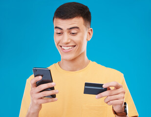 Credit card, ecommerce and man with a smartphone, payment and transaction on a blue background. Person, guy and happy model with a cellphone, digital app and online banking with finance and savings
