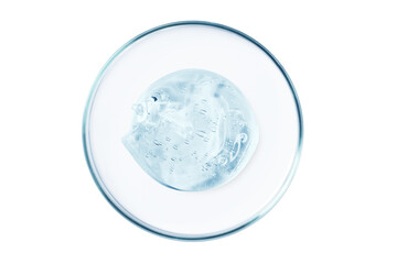 Petri dish with a drop and a smear of a transparent gel or serum on an empty background.