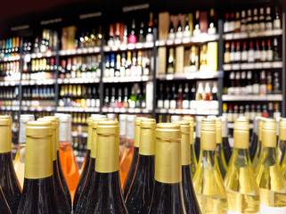 defocused alcohol (wine, champagne, liquor, whiskey) on store shelves - obrazy, fototapety, plakaty