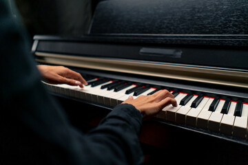 Close-up of a woman's hands in silver rings playing beautiful lyrical melody on the piano keys 