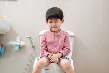 Asian boy Sitting on the toilet bowl