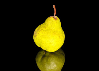 One ripe tasty green pear, close-up, on a black background.