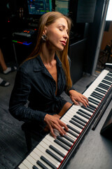 Female pianist preparing for a concert and playing a lyrical melody on the piano keys in music...