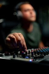A close-up of a mixing console device used by a man working as professional sound engineer in a...