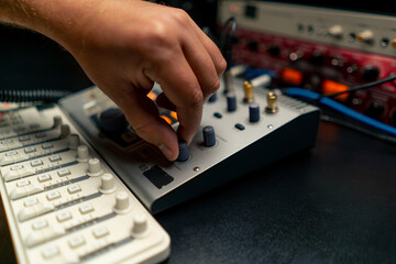 close-up shot of the male hand of a sound engineer switching settings on mixing console for...