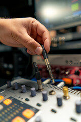 close-up shot of the male hand of a sound engineer switching settings on mixing console for...