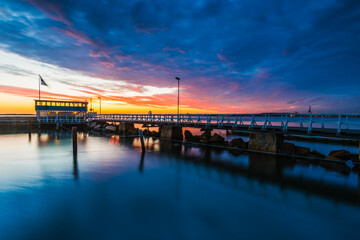 Fototapeta premium Harbor Pier at Dusk: Stunning Sunset Reflections on Water, Gothenburg