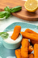 fish sticks, fish fillet fingers breaded served with tartar sauce, vertical image. top view. place for text