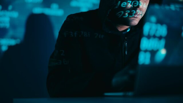 Man hacking into database, uploading a virus, conducting ddos attack on servers