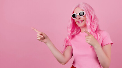 Woman in total pink pointing at mockup workspace for advert, marketing, promotion or text....