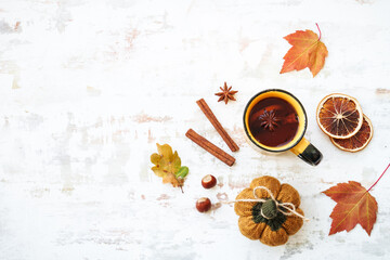 Fall background. Autumn tea, spices, orange leaves, and home decor. Flat lay with copy space.