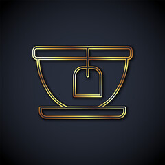 Gold line Cup with tea bag icon isolated on black background. Vector