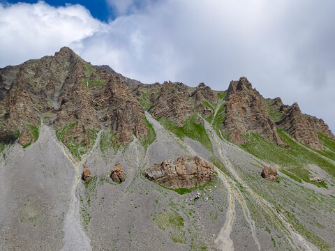 Panoramic view of rocky sharp mountain ridge in valley Valle Stura in Colle Del Puriac, Piemonte, Italy, Europe. Hiking tour in Italian Alps on sunny summer day. Peaceful serene atmosphere. Blue sky