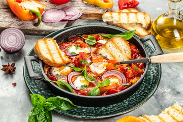 Hot breakfast shakshuka with fried eggs, tomato sauce in a pan