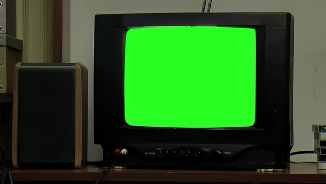 Old TV Green Screen in Dark Room. Close Up. You can replace green screen with the footage or picture you want. You can do it with “Keying” effect in After Effects.