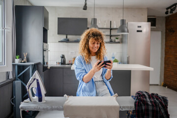 young woman play video games on smartphone mobile phone at home