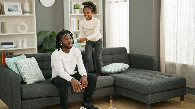 African american father and daughter sitting on sofa stressed for disturb at home