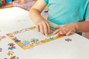 A boy collects a picture puzzle, educational games for children, close-up