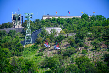 View from central part of Grenoble city to Bastille fortres witn mountains around, old cable car, Isere, France