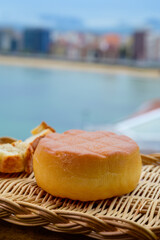 Spanish hard smoked cow cheese from Pria, Asturias, served outdoor with view on San Lorenzo beach in Gijon